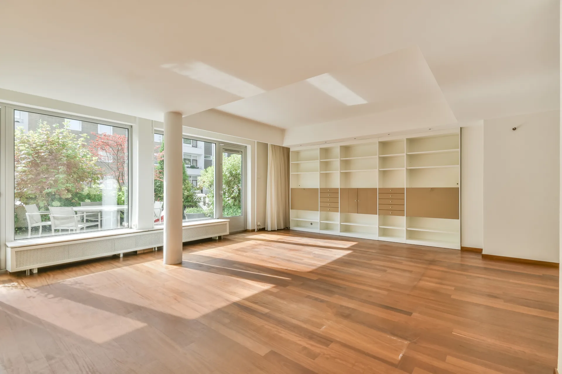 Wohnzimmer einer Eigentumswohnung mit Parkett und Terrassenzugang