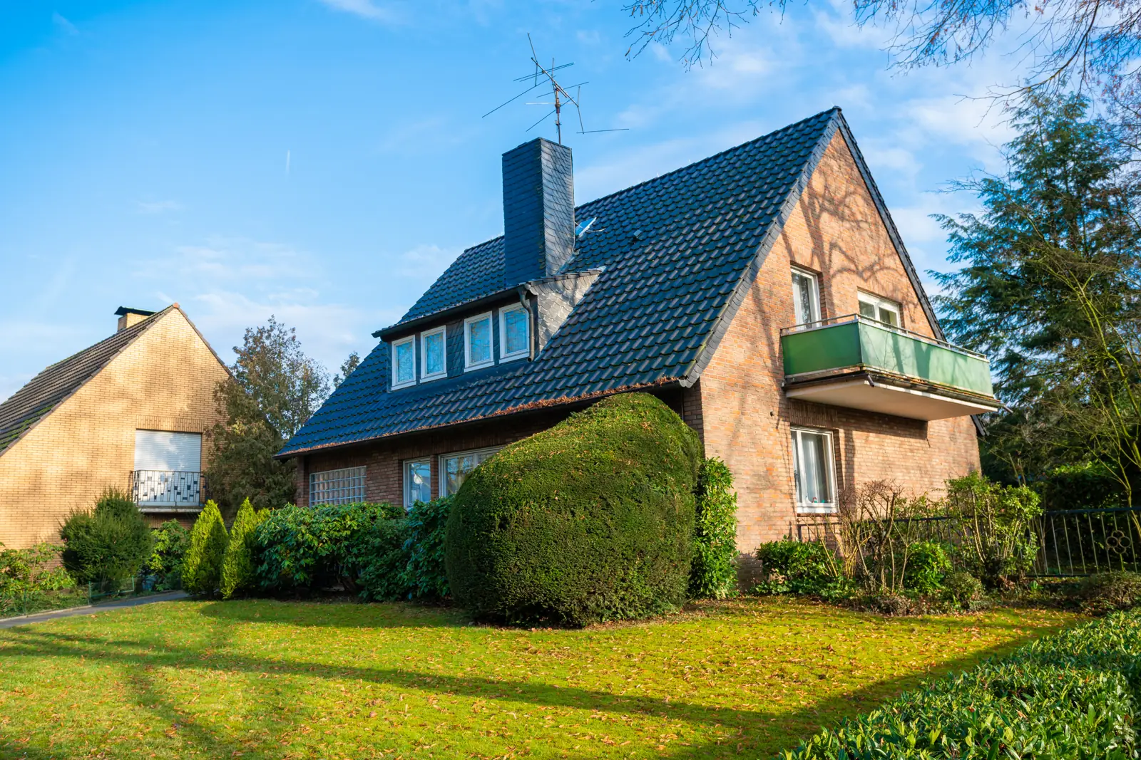Einfamilienhaus mit Klinkerfassade, Balkon und gepflegtem Rasen, Haus in Bissendorf verkaufen