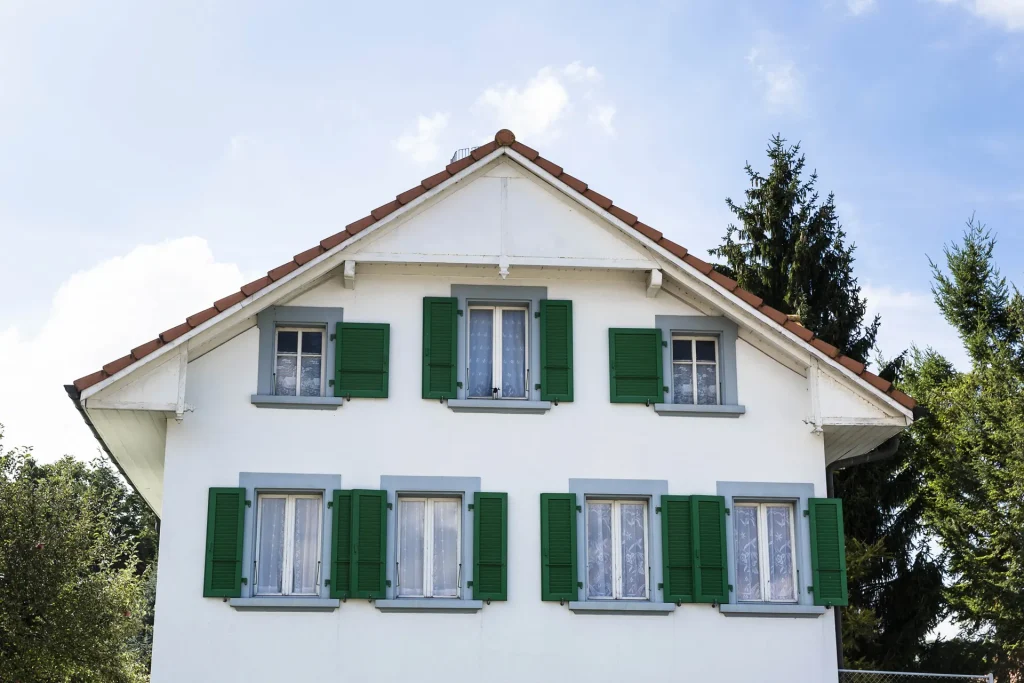 Weißes Einfamilienhaus mit grünen Fensterläden und Satteldach, Immobilienmakler für Wallenhorst bei Osnabrück