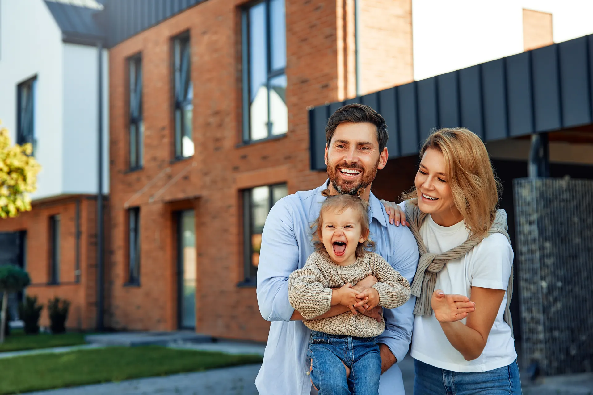 Junge Familie vor einem modernen Haus mit Klinkerfassade, Haus in Wallenhorst kaufen oder verkaufen